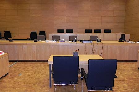 Zwei Stühle stehen vor einem Tisch - dahinter eine Richterbank
