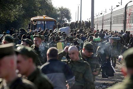 Russische Rekruten versammeln sich auf einem Bahnhof.