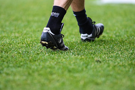 Fußballschuhe Fußballerbeine Hintergrund Rasen