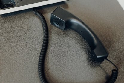 Telefonhoerer liegt auf dem Tisch