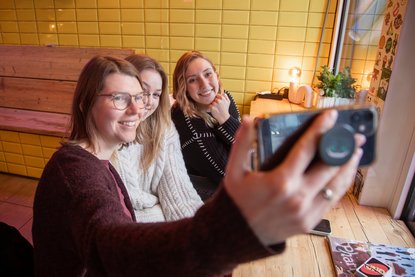 Junge Frauen machen ein Selfie von sich zusammen.