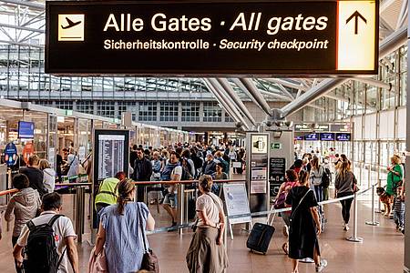 Fluggäste im Helmut Schmidt Flughafen in Hamburg vor dem Sicherheitscheck.