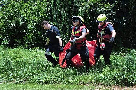 Rettungskräfte tragen die Leiche eines Überschwemmungsopfers, das aus dem Fluss Jukskei geborgen wurde.