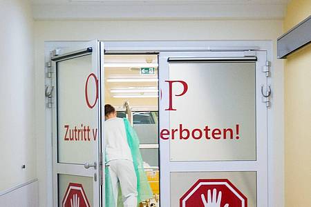 Ein Pfleger schiebt in der Asklepios Klinik Altona in Hamburg einen Patienten durch die Personenschleuse in den OP-Bereich.