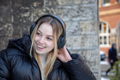 Frau mit Kopfhörer lacht.