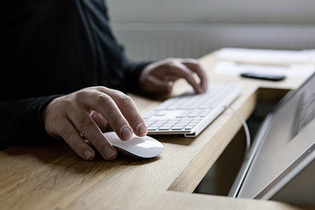 Männerhände arbeiten am Computer mit Maus und Tastatur