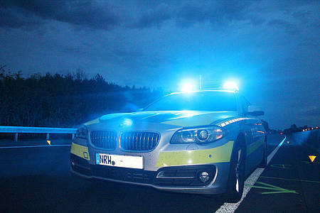 Polizeiwagen mit Blaulicht fährt bei einsetzender Dunkelheit