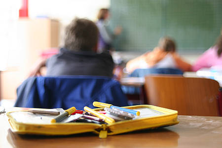 Kind mit Gesicht zur Tafel im Klassenzimmer