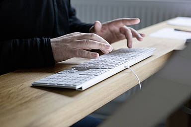 Frau tippt auf einer Tastatur