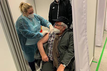 Älterer Mann wird mit Corona-Impfstoff geimpft